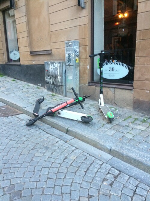 Kick-Scooter liegen quer über einem Gehsteig in Södermalm/Stockholm und behindern Fußgänger
